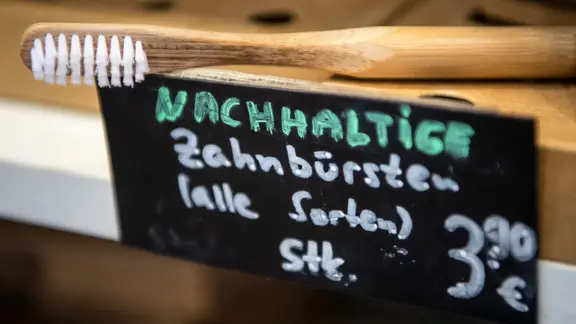 In einem Laden wird eine nachhaltige Zahnbürste aus Holz angeboten.