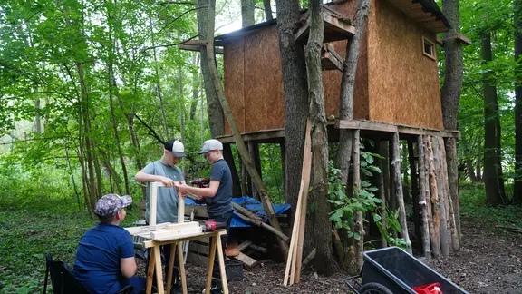 Lukas, Levi und Leo bauen vor ihrem Baumhaus.
