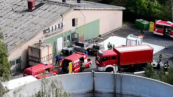 Feuerwehrautos stehen vor einer Schweinemastanlage