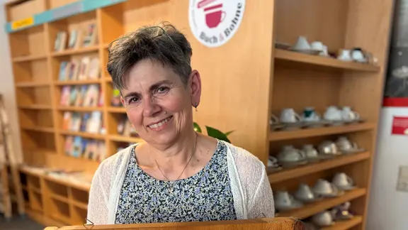 Eine Frau steht vor einem Bücherregal