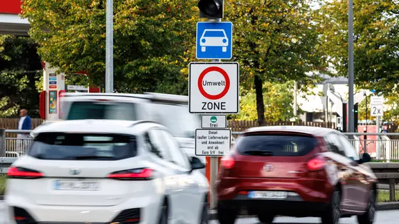 Ein Verkehrsschild zwischen fahrenden Autos weist auf die Umweltzone hin.