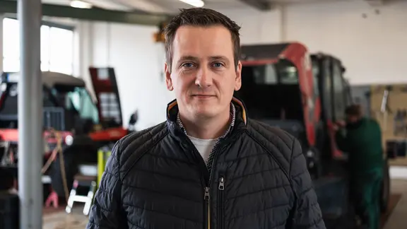Daniel Schemionek. Ein Mann steht in einer großen Garage.