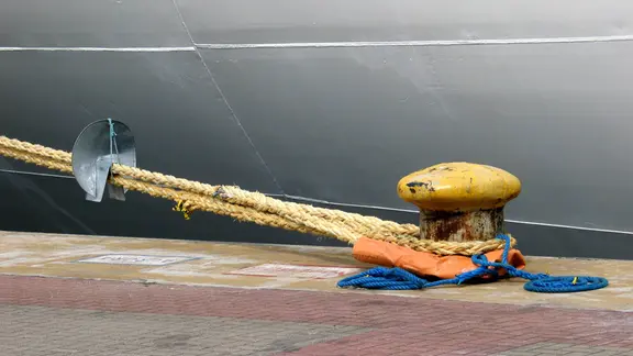 Ein weißes Schiff ist mit einem Tau an einem Anleger festgemacht. (Symbolbild)