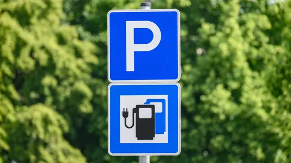Ein Parkplatzschild mit einem Schild für Ladesäulen.