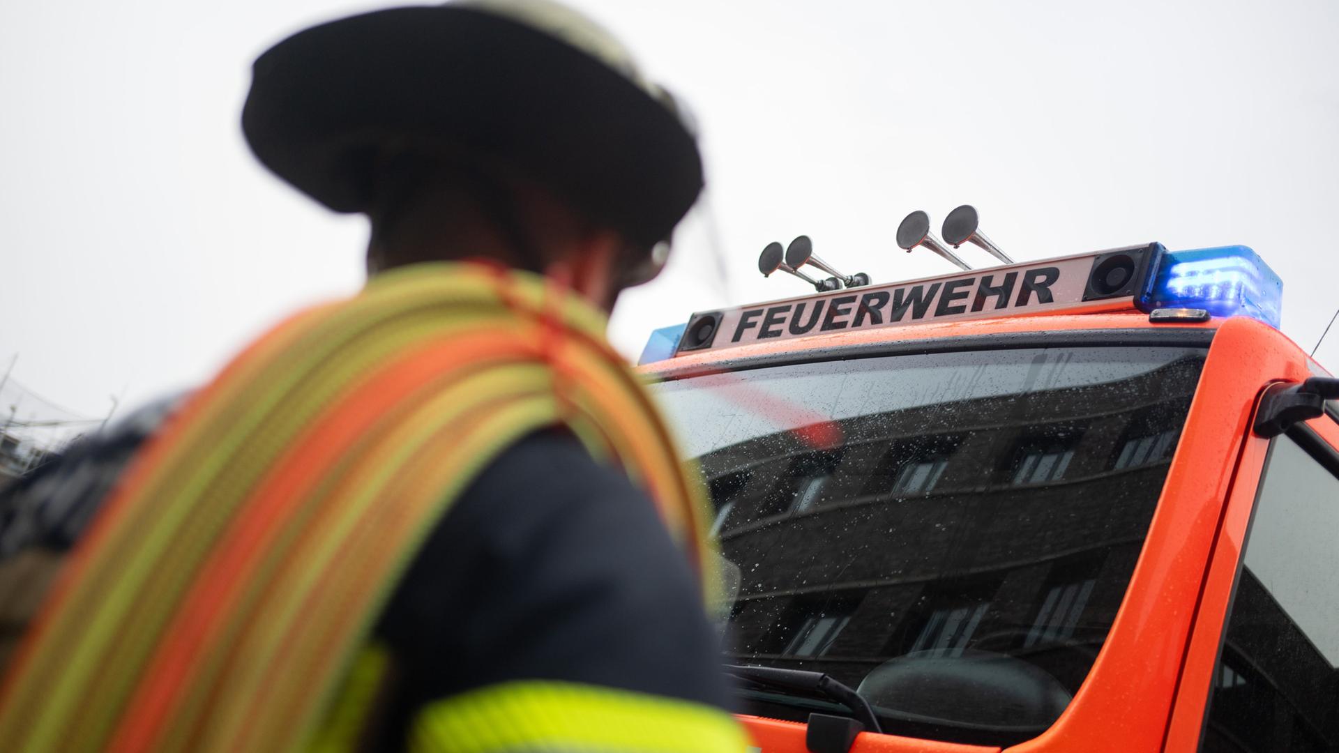 Symbolbild: Eine Einsatzkraft der Feuerwehr steht vor einem Einsatzfahrzeug. | picture alliance/dpa | Marijan Murat