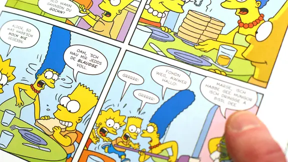 Ein Messebesucher liest am 18.03.2016 einen Comic "Die Simpsons auf Sächsisch" auf der Leipziger Buchmesse in Leipzig (Sachsen). 