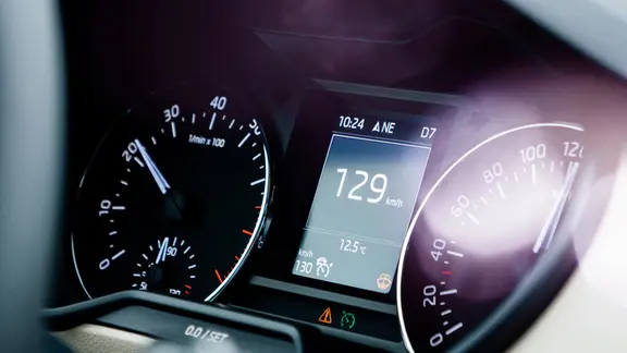 Der Tacho eines Autos bei der Fahrt auf der Autobahn.