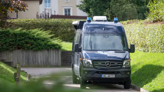 Ein Polizeiauto steht in einer Einfahrt.