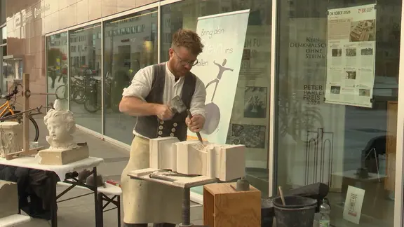 Ein Steinmetz zeigt sein Handwerk beim Aktionstag in Dresden