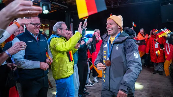 Ministerpräsident Mario Voigt (CDU) und Georg Maier (SPD), Thüringer Minister für Inneres, Kommunales und Landesentwicklung und Stellvertretender Ministerpräsident beim Empfang der erfolgreichen Skeleton-Fahrer Christopher Grotheer (GER), rechts, und Axel Jungk (GER) in der Nacht im Deutschen Haus. 
