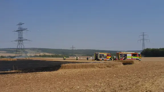 Die Feuerwehr löscht einen Feldbrand bei Eisenach.
