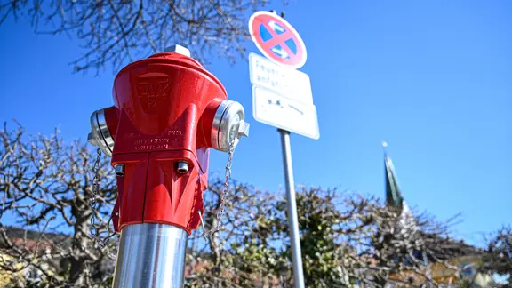 Ein Feuerwehr-Hydrant steht vor einem  Verkehrsschild