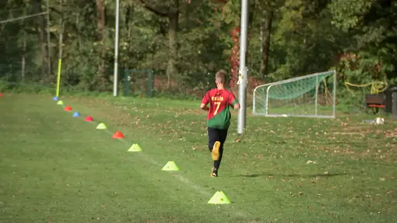 Ein Junge läuft auf einem Fußballplatz
