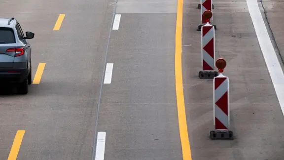 Ein PKW fährt über eine verengte Fahrbahn in einer Baustelle auf der Autobahn.