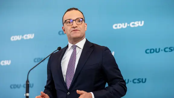 Unionsfraktionschef Jens Spahn steht an einem Rednerpult, hinter ihm steht auf blauem Grund mehrfach "CDU - CSU"