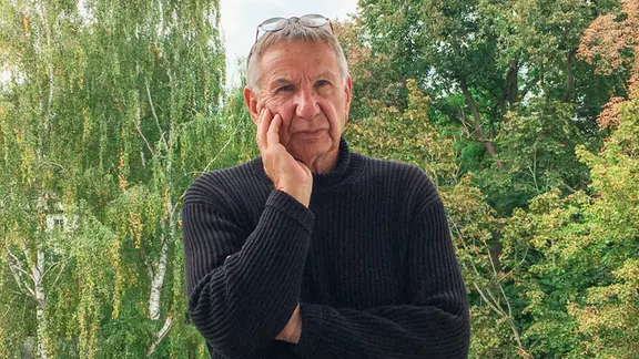Regisseur Volker Koepp trägt einen schwarzen Pullover und blickt in die Kamera.