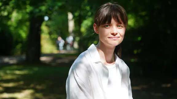 Lisa Edeline Gimpel sitzt im Friedenspark in Leipzig. 