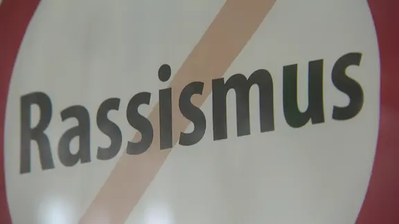 Schild zeigt das durchgestrichene Wort "Rassismus"