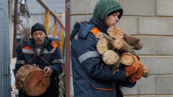 Gemeindeangestellte helfen Rentnern bei der Vorbereitung von Brennholz während eines Stromausfalls in Tiraspol