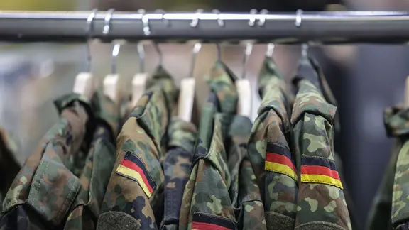 Feldjacken hängen am Stand der Bundeswehr. 