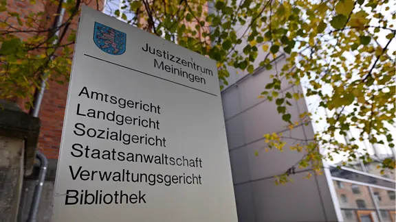 Eine Tafel vor dem Justizzentrum Meiningen. In dem Gebäude befinden sich das Amtsgericht, das Landgericht, das Sozialgericht, die Staatsanwaltschaft, das Verwaltungsgericht und eine Bibliothek.