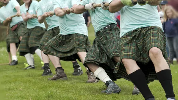 Männer beim Tauziehen während der Highland Games
