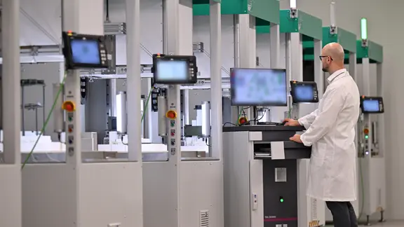 Mitarbeiter steht an einem Arbeitsplatz in der Fügestation der Pilotfertigungsanlage für SOEC-Elektrolyseure von Thyssenkrupp nucera und Fraunhofer IKTS in Arnstadt