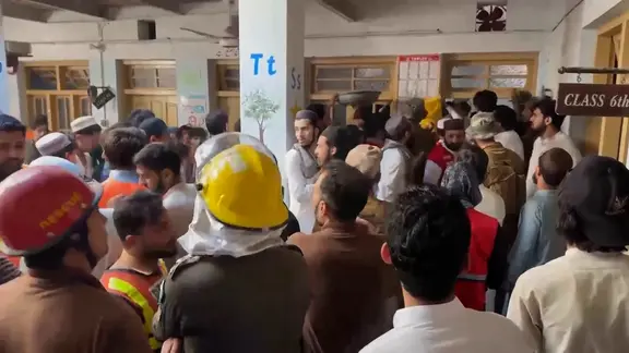 Rettungskräfte und Eltern in einem Innenhof einer Schule in Peschawar in Pakistan. Es gibt Tote und Verletzte nach dem das Dach einer Schule eingestürzt ist.