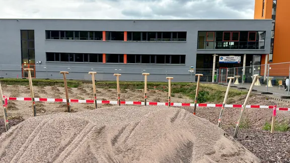 Mehrere Spaten stecken in einem Sandhaufen vor dem neuen Berufsschulzentrum in Eisenach