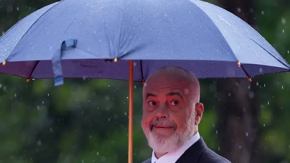 Ein Mann unter einem Regenschirm (Edi Rama, Premierminister Albaniens)