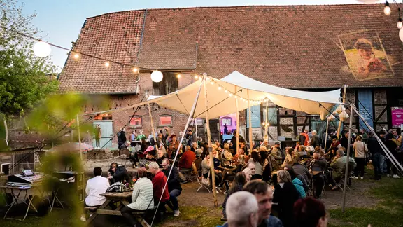 Menschen sitzen vor einem Gebäude