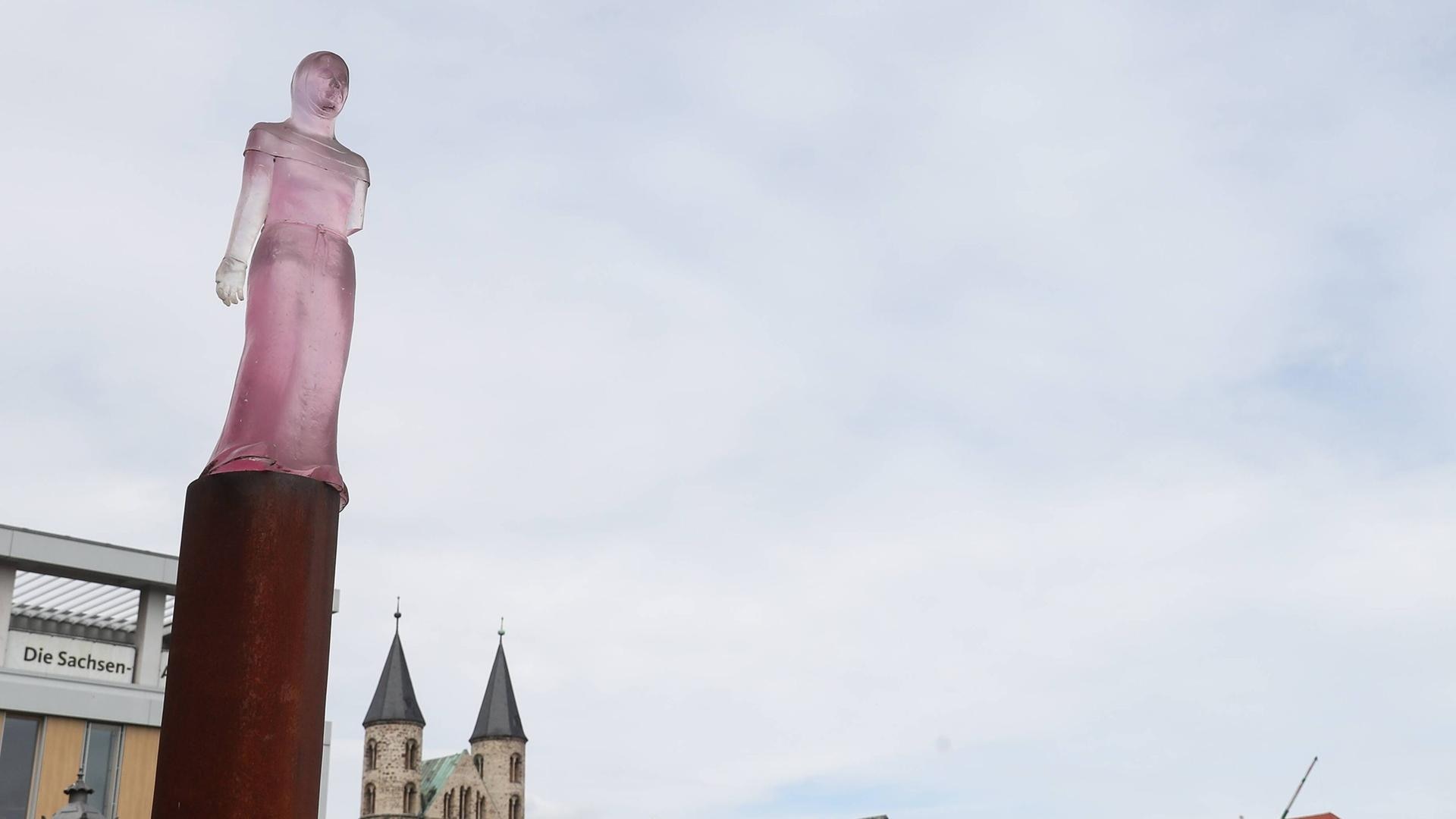 eine rosfarbene Statue der Mechthild von Magdeburg auf einem langen Sockel | IMAGO/Christian Schroedter