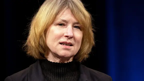 Die Schauspielerin Corinna Harfouch, mit halblangen blonden Haaren in schwarzer Kleidung. 