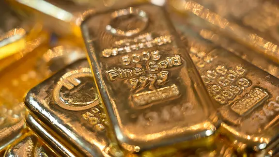 Goldbarren liegen auf einem Tisch.