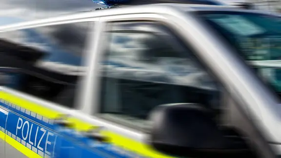 Fahrender Polizeiwagen mit Blaulicht