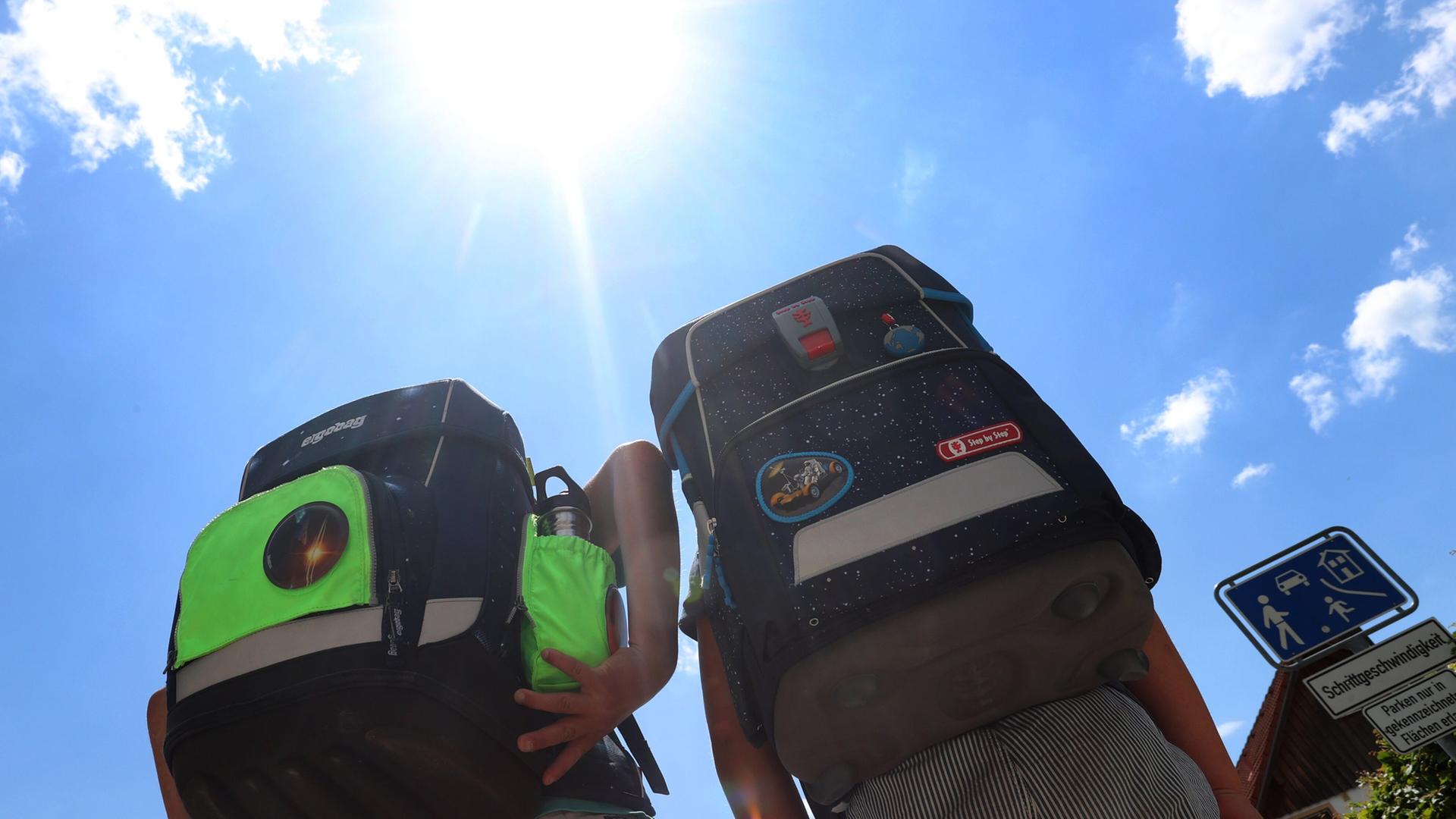 Zwei Kinder laufen mit ihren Ranzen im Sonnenschein.  | picture alliance/dpa | Karl-Josef Hildenbrand