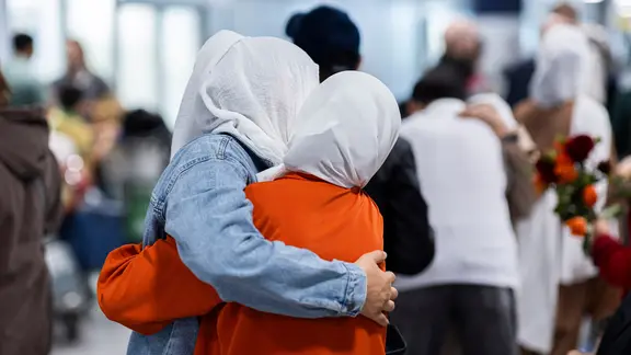 Menschen aus Afghanistan, die zuvor mit einem Flugzeug auf dem Flughafen Hannover-Langenhagen gelandet sind, werden am Flughafen begrüßt.