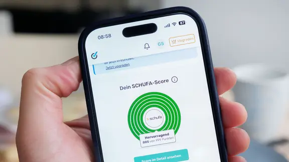 Auf einem Smartphone wird der Schufa-Score einer Person angezeigt.