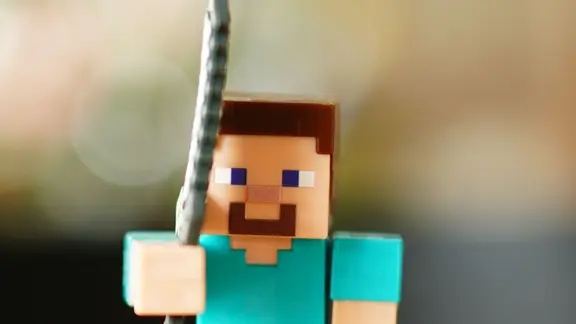 Eine Figur aus Minecraft mit einem erhobenen Schwert
