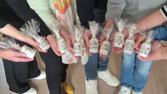 Menschen halten Kerzen in der Hand.
