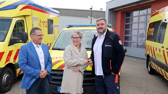 Ein Mitarbeiter der Malteser erhält den Autoschlüssel für ein neues Rettungsfahrzeug.