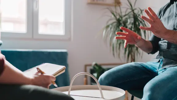 Ein Mann gestikuliert während einer Therapiesitzung