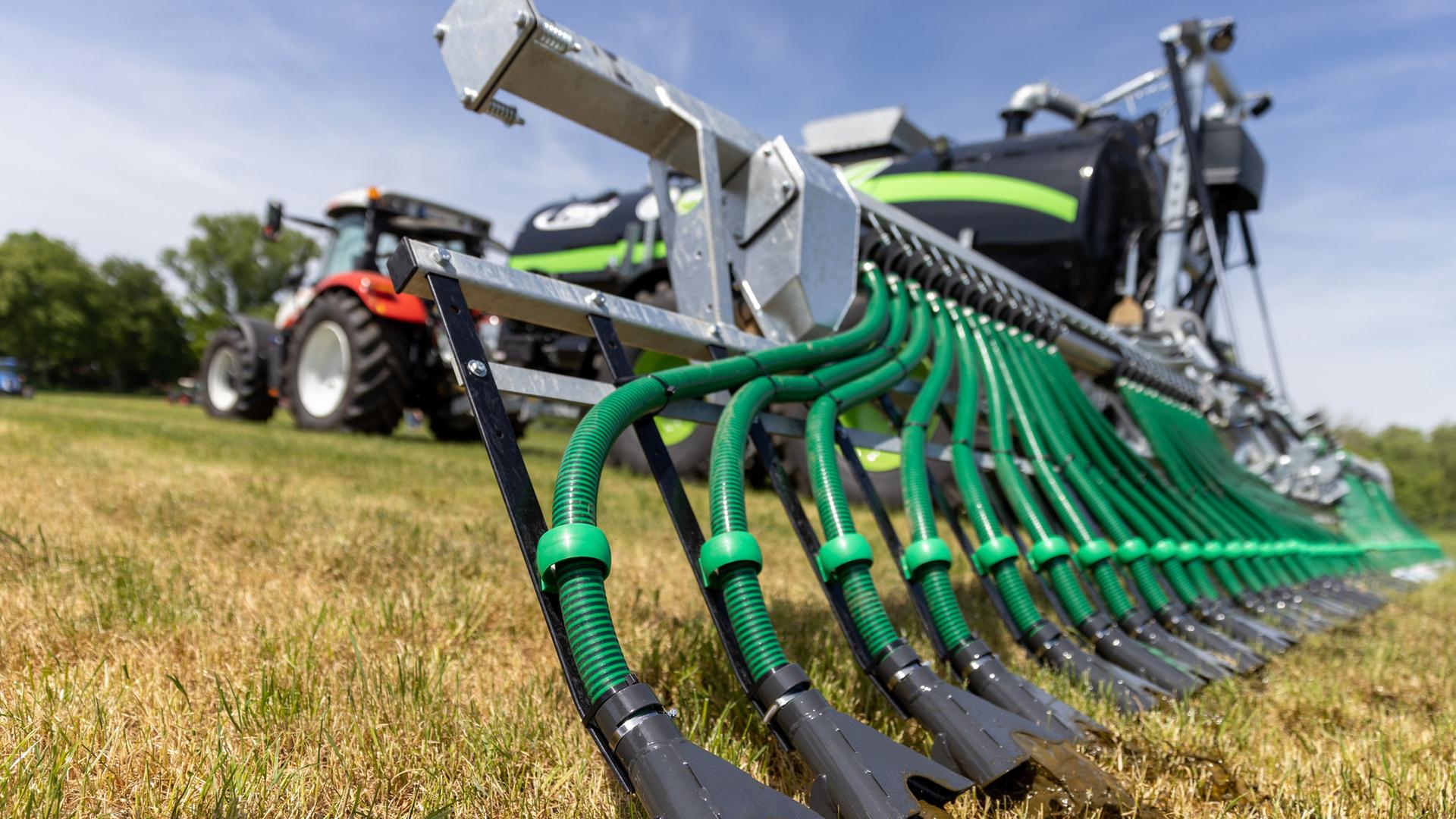 Ein Traktor zieht während einer Vorführung beim Gülletag, ein Schleppschlauchgestänge zur bodennahen Gülleausbringung. | picture alliance/dpa | Daniel Karmann