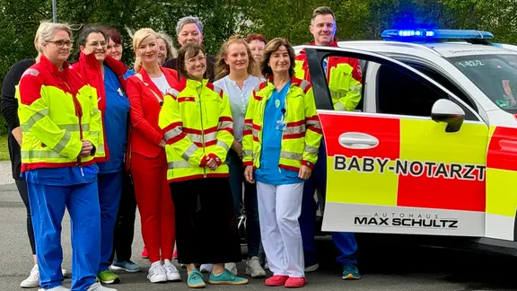Ein Rettungsteam steht vor dem neuen Babynotarztwagen in Suhl