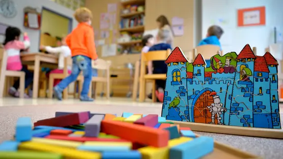 Spielzeug liegt in einer Kindertagesstätte auf dem Boden.