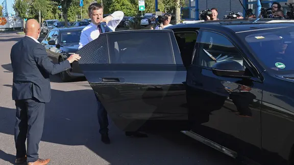 Ein Mann (Sven Schulze) steigt aus einem Auto.