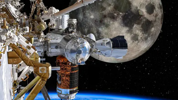 Die Raumstation ISS vor dem Mond