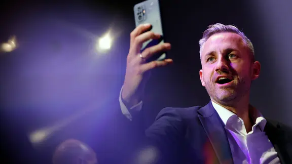 Ulrich Siegmund hält ein Smartphone in die Höhe