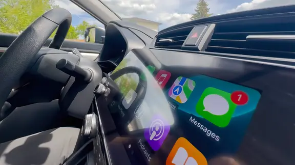Auf dem Touchscreen eines Autos sind verschiedene Apps, unter anderem für Nachrichten, zu sehen.
