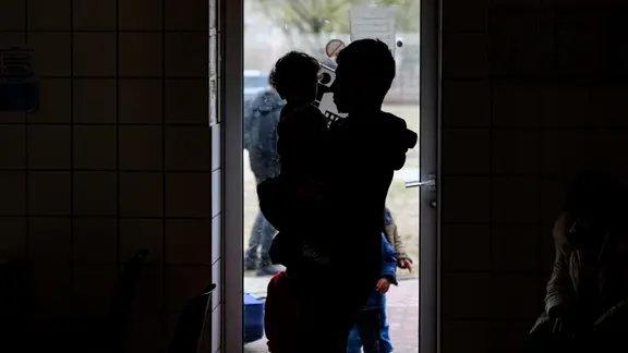 Die Silhouette eines Mannes, der ein Kind auf dem Arm hält.